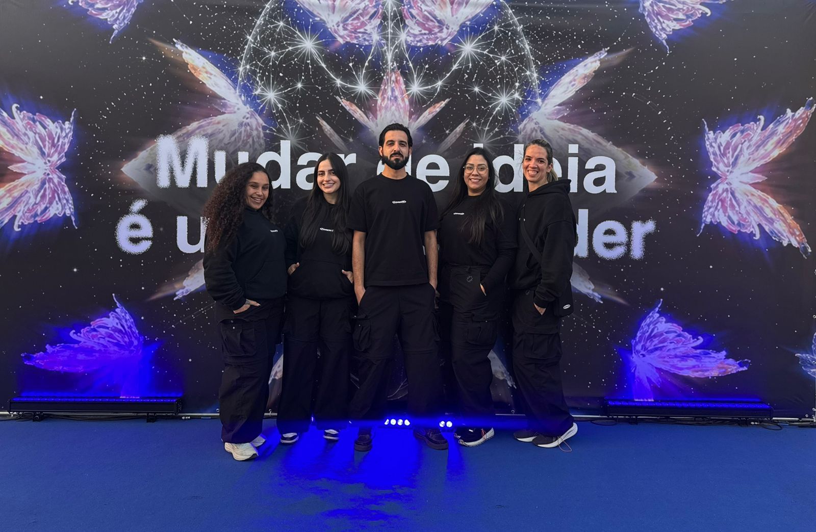 Equipe de credenciamento e recepção da 3S Onlife uniformizada diante do painel de um evento